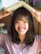 A woman holding a book over her head.