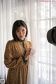 A woman standing in front of a window with a camera.