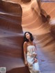 A woman leaning against a rock in a canyon.