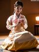 A woman in a white and gold hanbok sitting on the floor.