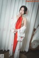 A woman in a white and red kimono posing for a picture.