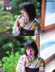 A woman in a kimono holding a popsicle in her hand.